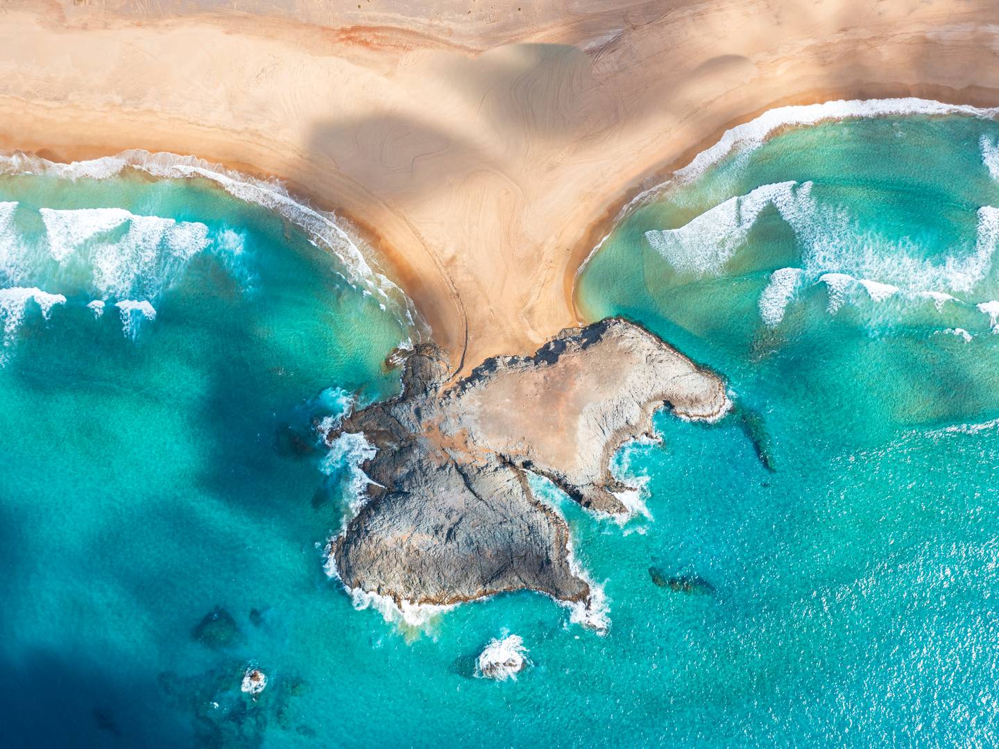 Kanaren Strandurlaub an der Bucht von Cofete auf Fuerteventura mit Sandstrand, Felsen und türkisblauem Atlantik aus der Vogelperspektive