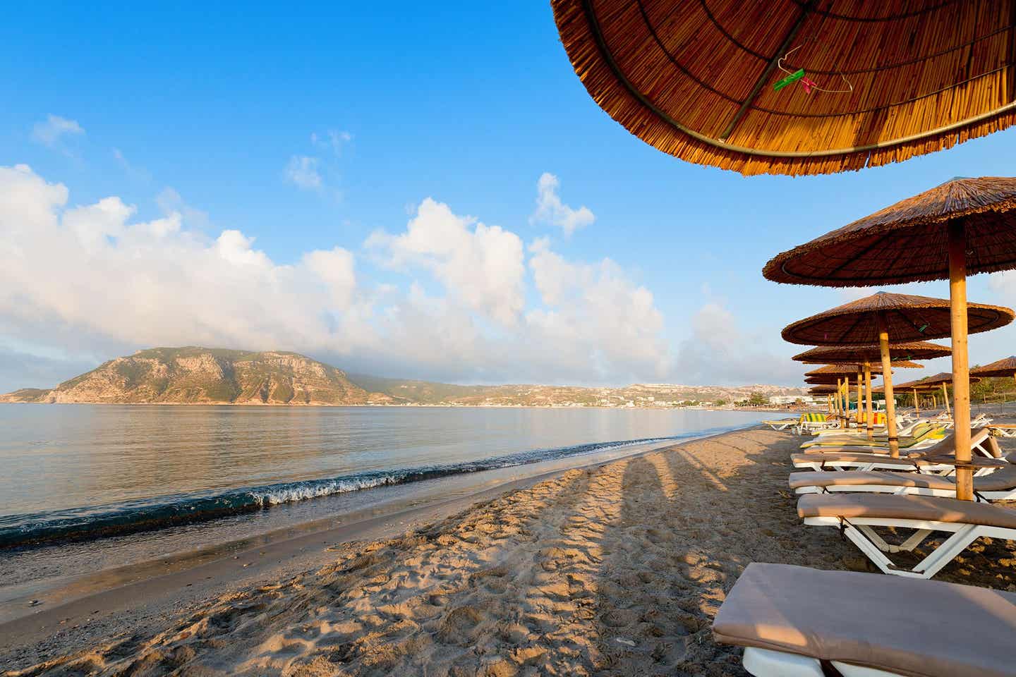 Sonnenanbeter in der Bucht von Lagada Beach auf Sandstrand vor türkisblauem Meer