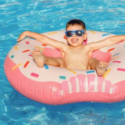 familienurlaub-kleiner-junge-auf-donutring-im-pool-g-1393517891.jpg