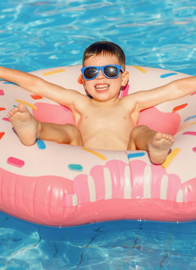 Aldiana mit der Familie Ein Junge mit Sonnenbrille treibt in einem Donutring in einem Hotelpool