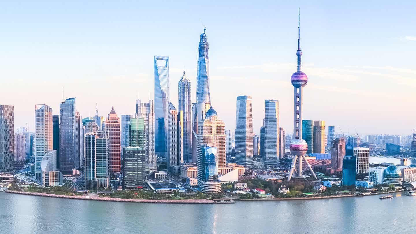 Modernes China in voller Breite: Die Skyline von Shanghai mit Oriental Pearl Tower und Shanghai Tower Skyline von Shanghai bei Sonnenuntergang mit Blick auf den Huangpu-Fluss und das moderne Stadtpanorama im Finanzviertel Pudong