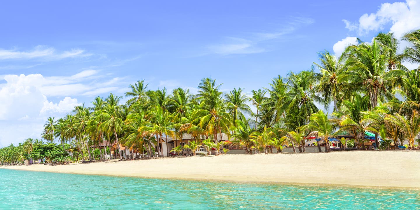 Panorama des Mae Nam Beach, einer der ruhigen Koh Samui Strände mit Palmen, hellem Sand und klarem Meer unter blauem Himmel