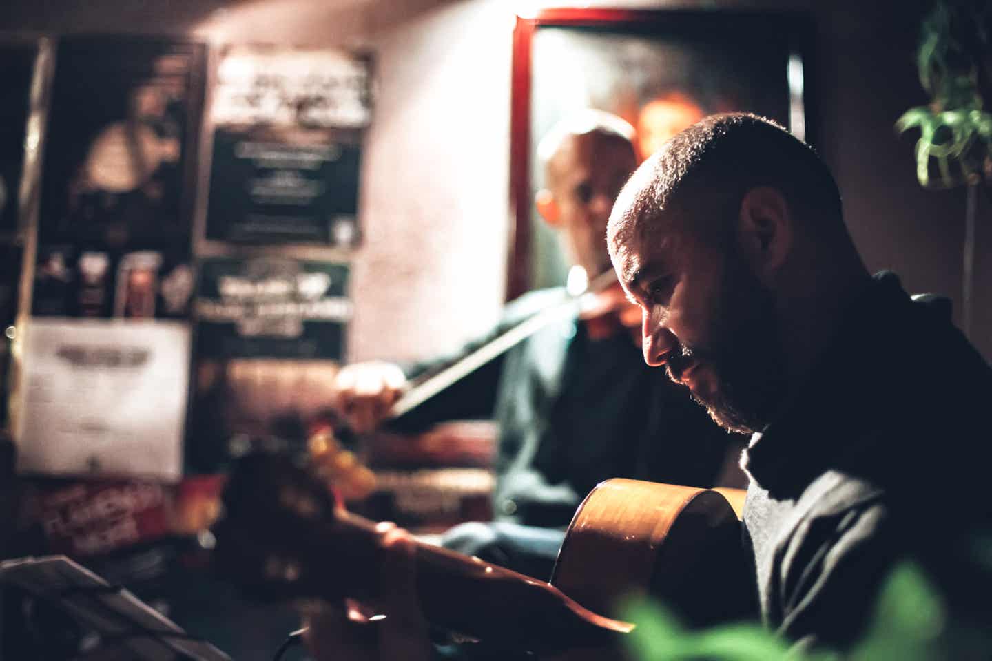 Mann spielt im Restaurant Gitarre