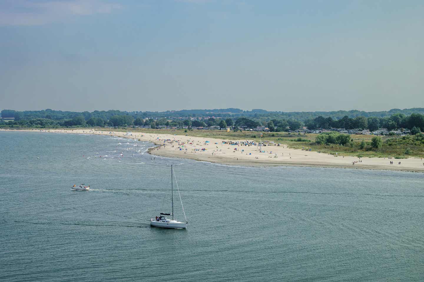 Travemünde Urlaub mit DERTOUR. Luftaufnahme des Strands von Travemünde mit Segelboot auf der Ostsee