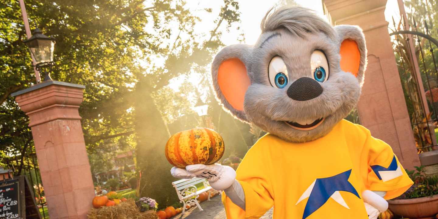 Das Europa-Park Maskottchen Ed Euromaus mit einem Kürbis in der Hand