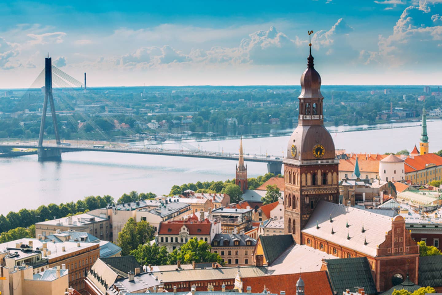 Rundreisen Lettland: Panoramabild von Lettlands Hauptstadt Riga mit Dom und Brücke über den Fluss Düna im Fokus