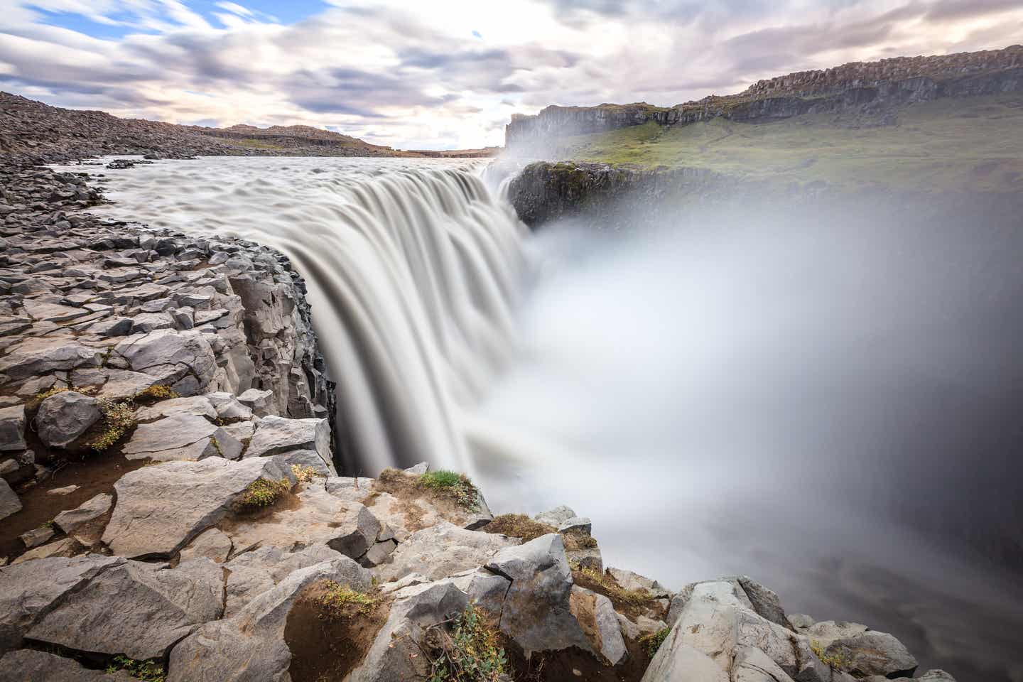 Die Wasserfluten des Dettifoss auf Island stürzen über karges Gestein in die Tiefe.