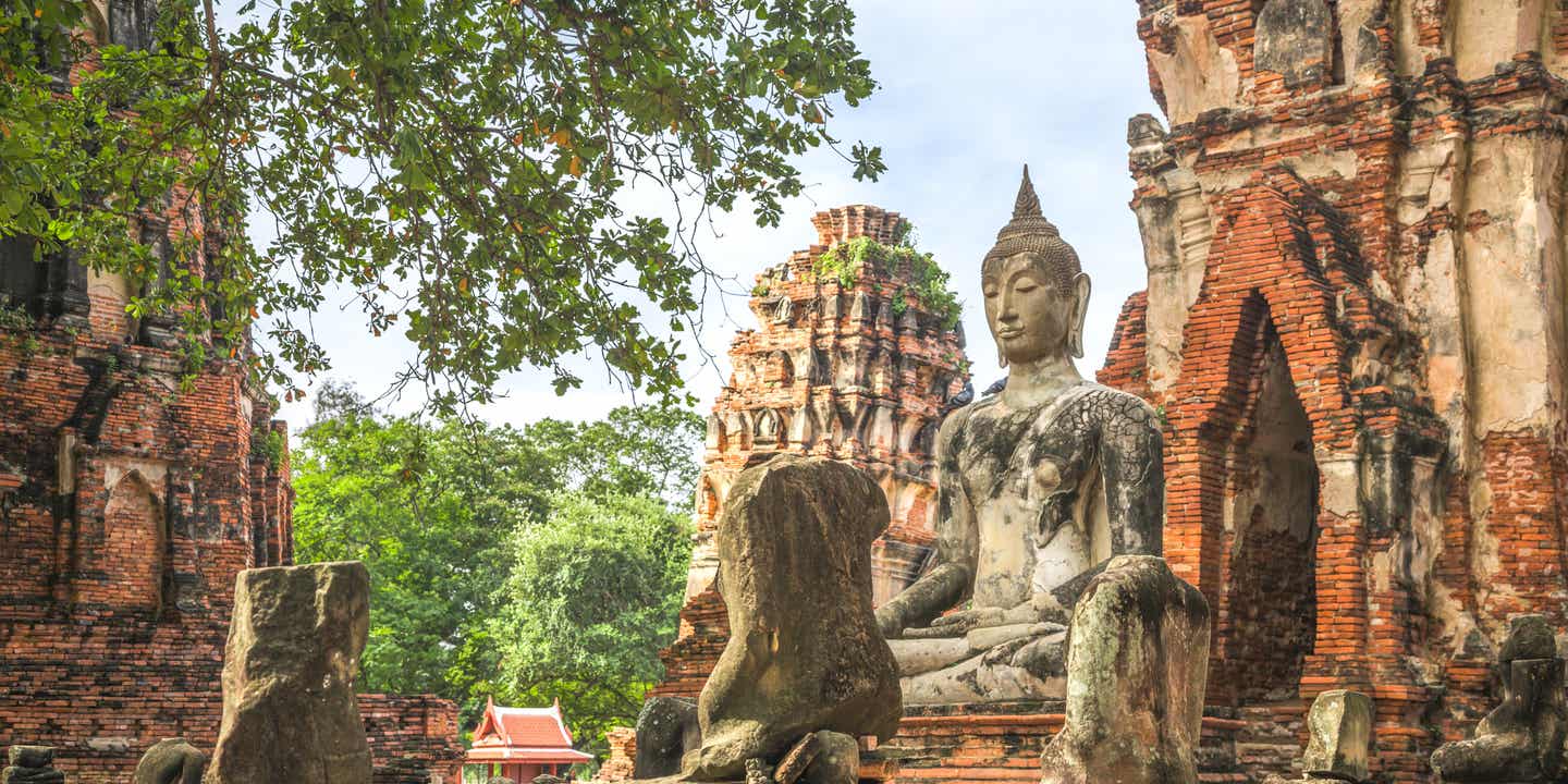 Sitzende Buddha-Statue vor einem der historischen Tempel von Ayutthaya