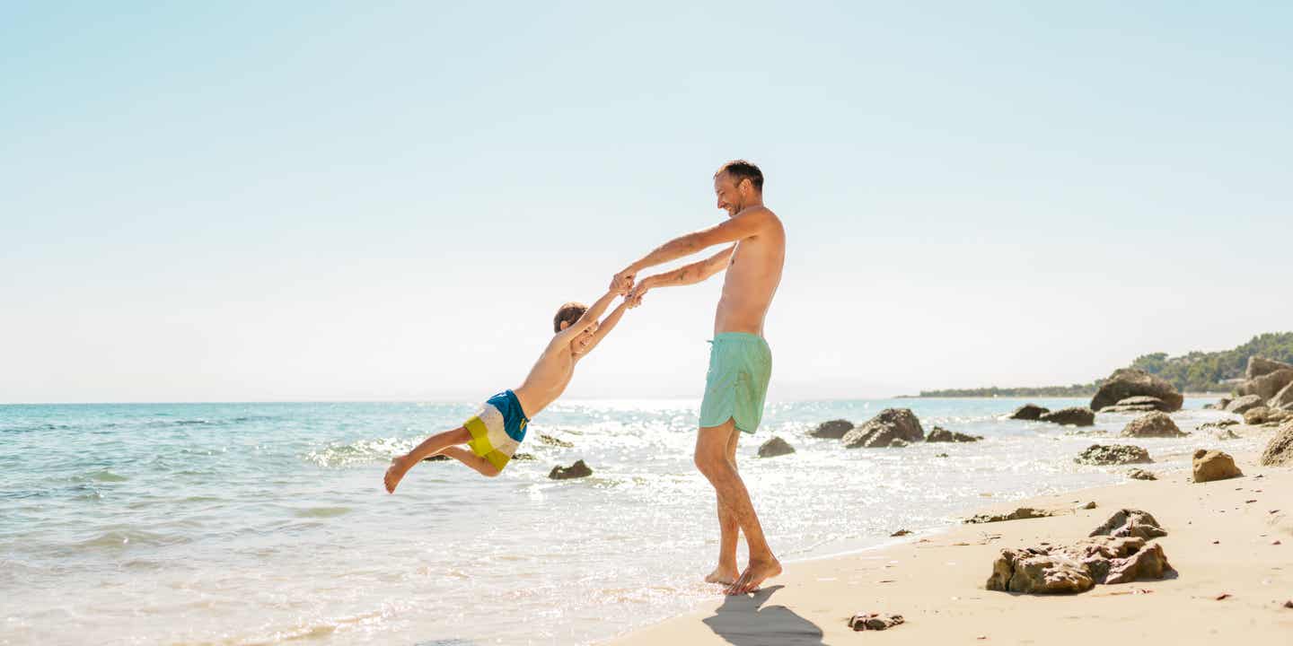 Familie am Strand unter der griechischen Sonne