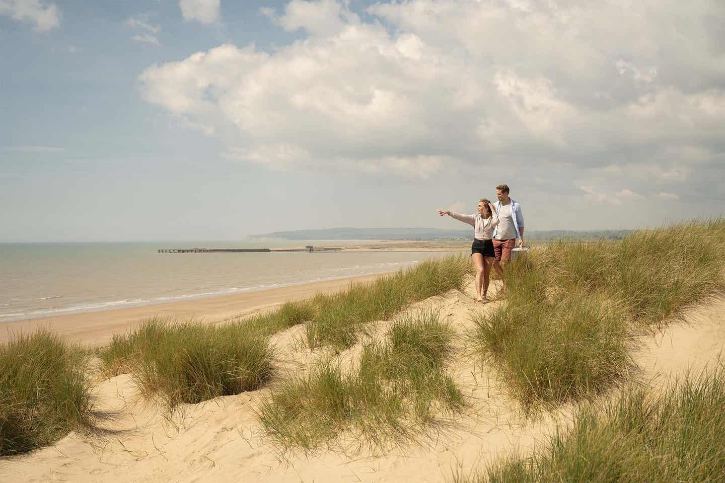 Ein junges Paar spaziert zwischen den Dünen am Ostsee-Strand