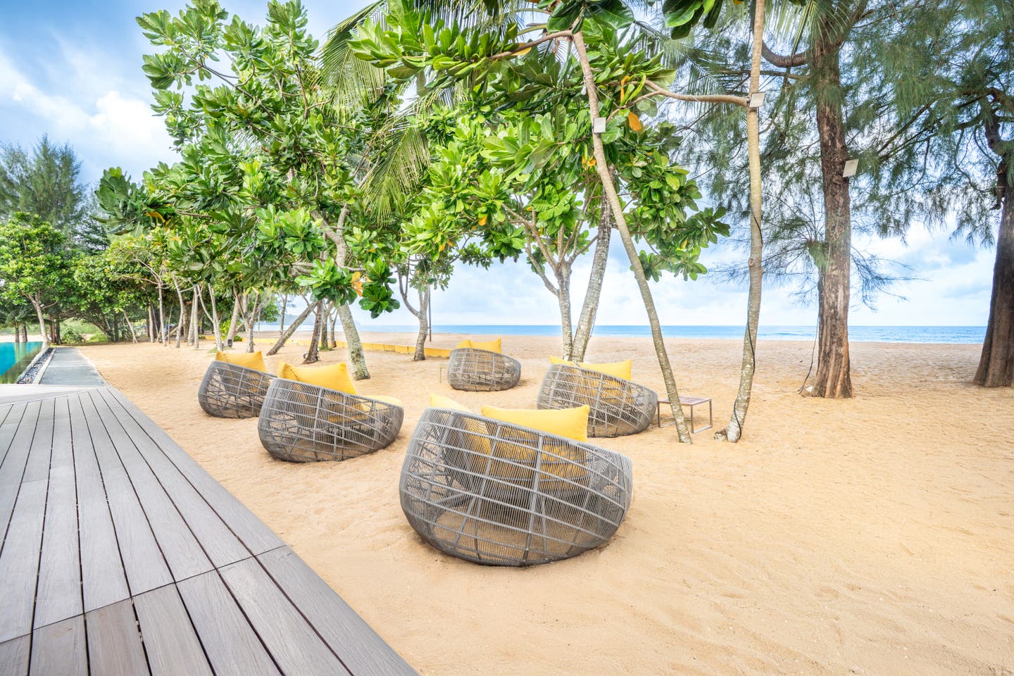 Lounge am Strand unter tropischen Bäumen