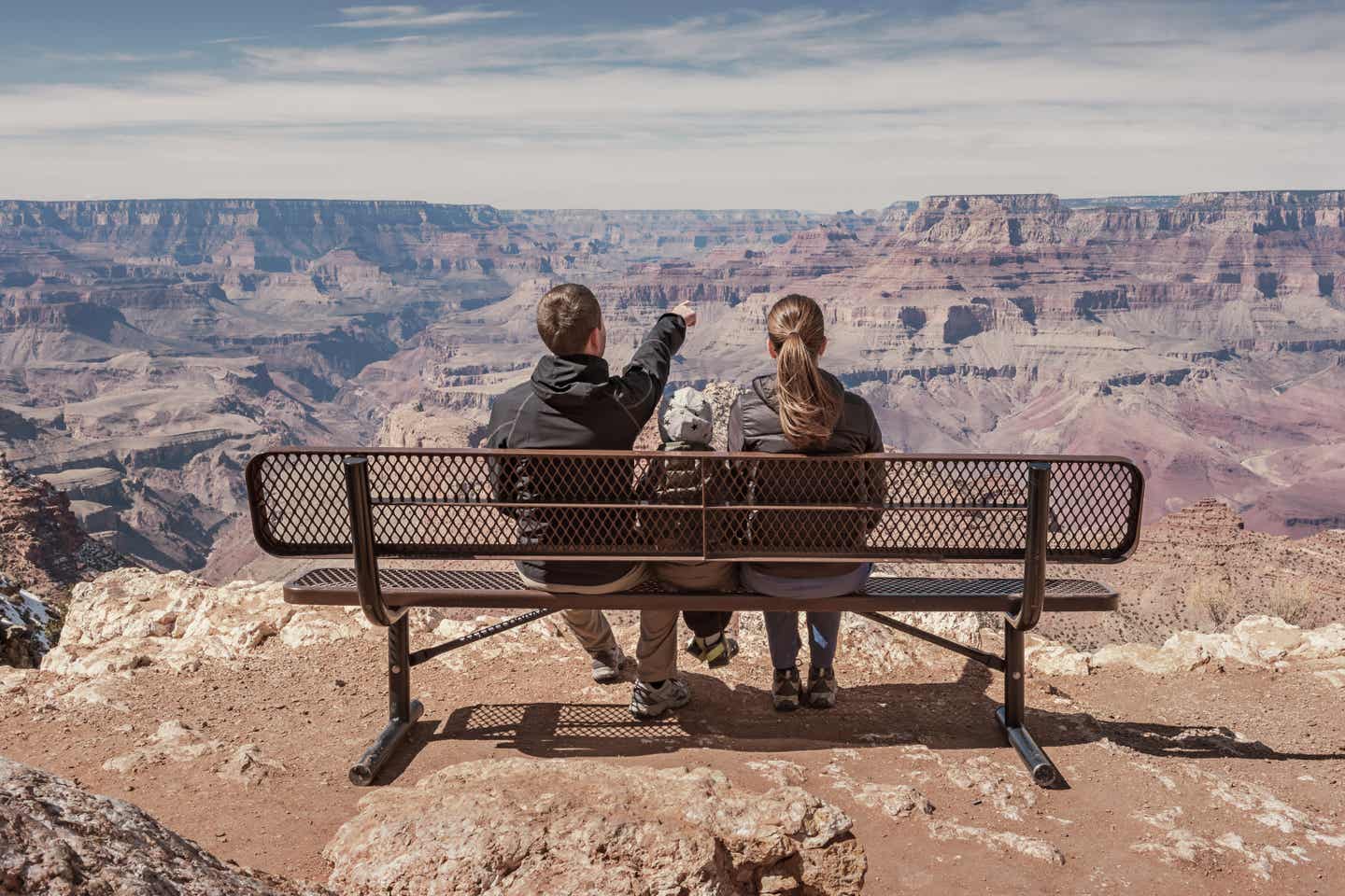 Arizona Urlaub mit DERTOUR. Familie auf einer Bank blickt in den Grand Canyon