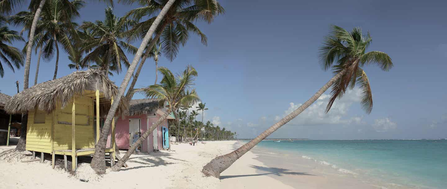 Punta Cana Urlaub mit DERTOUR. Bunte Hütten und Palmen am Strand von Punta Cana