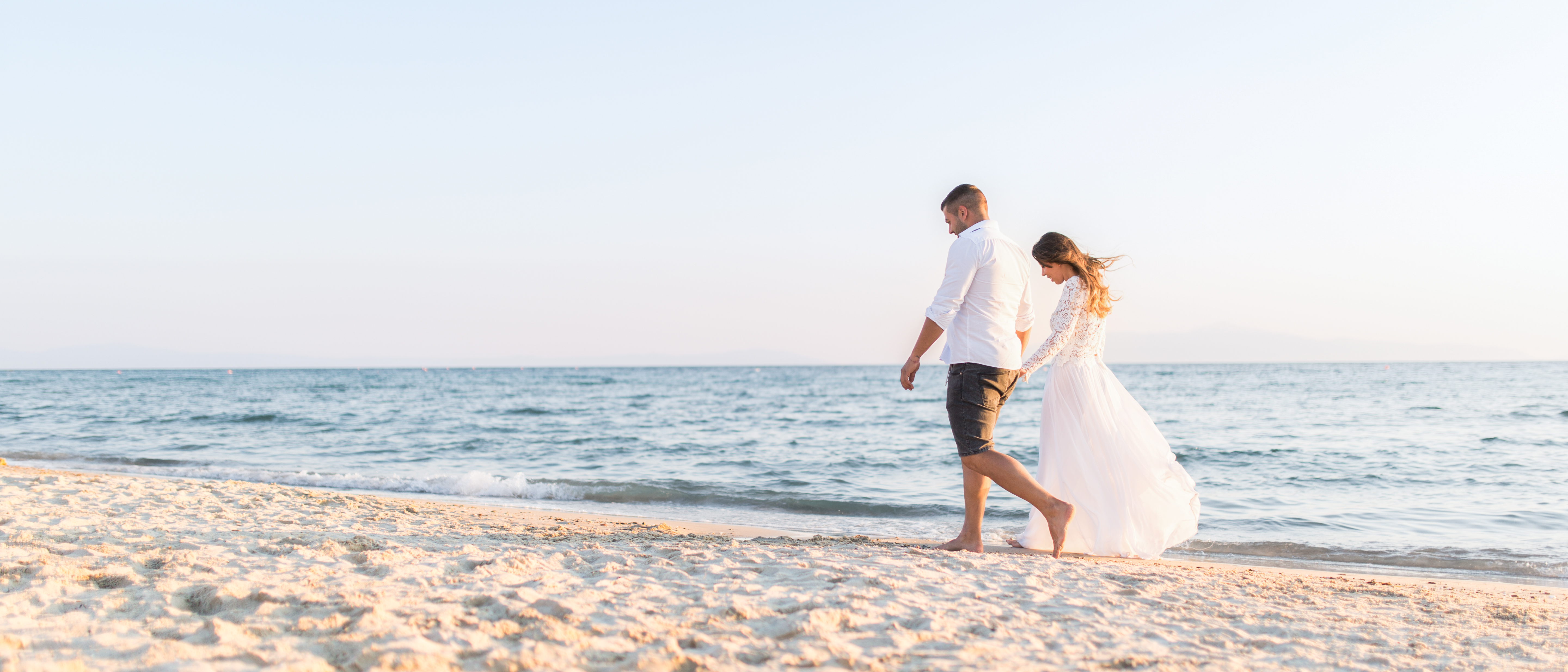 Ehepaar spazieren nach ihrer Strandhochzeit auf den Seychellen