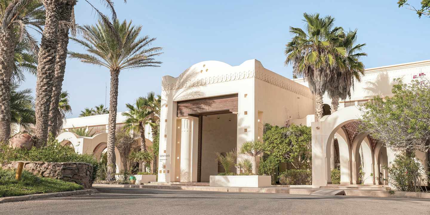 Frontale Perspektive auf weißes Gebäude mit Palmen des Sentido Djerba Beach in Tunesien