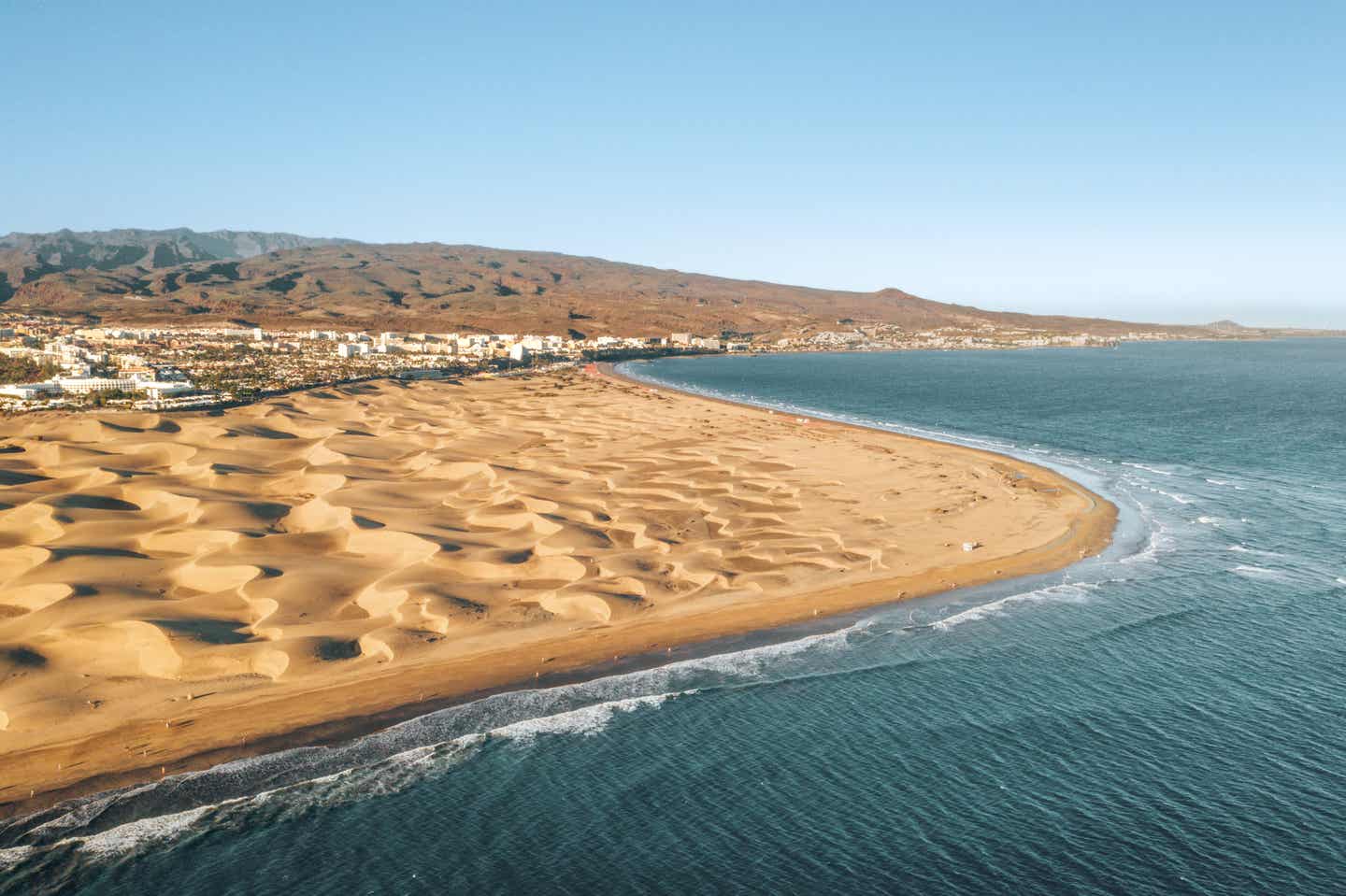 Blick auf die bekannten Dünen von Maspalomos auf Gran Canaria, die vom Meer umspült werden