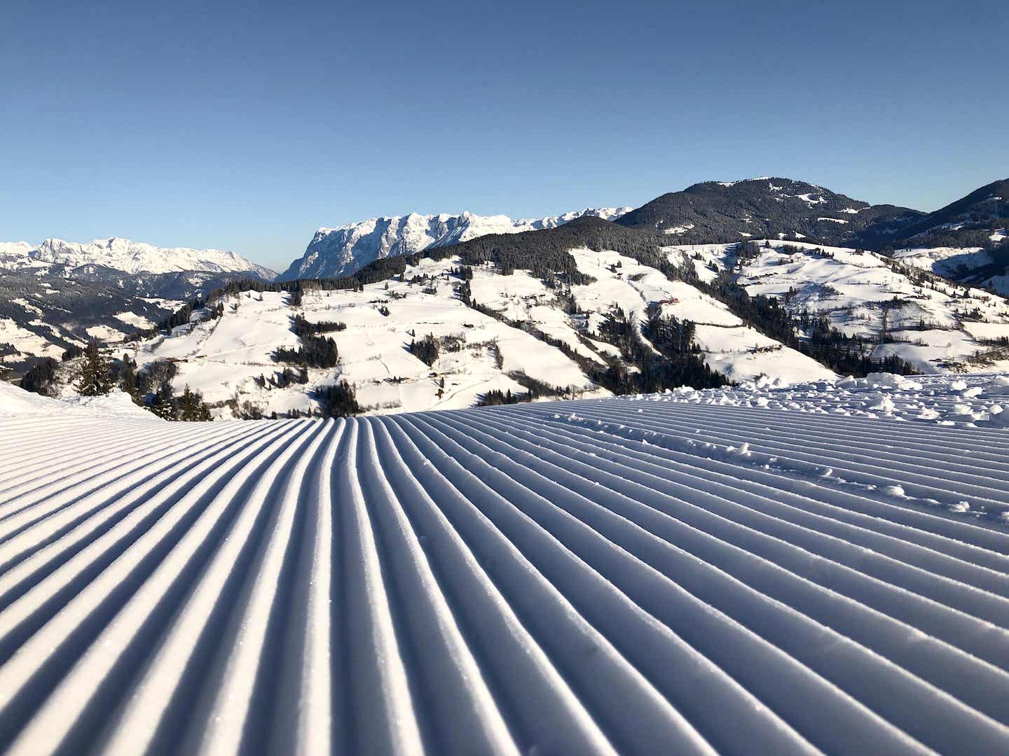 Unberührte Piste in der Salzburger Sportwelt von Ski amadé mit Bergen im Hintergrund