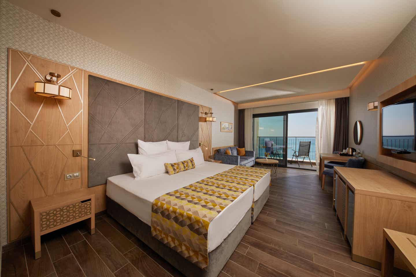 Zimmerbeispiel im Secrets Sunny Beach Resort and Spa Zimmer mit Doppelbett, Holzmöbeln und goldenen Akzenten im Secrets Sunny Beach Resort and Spa
