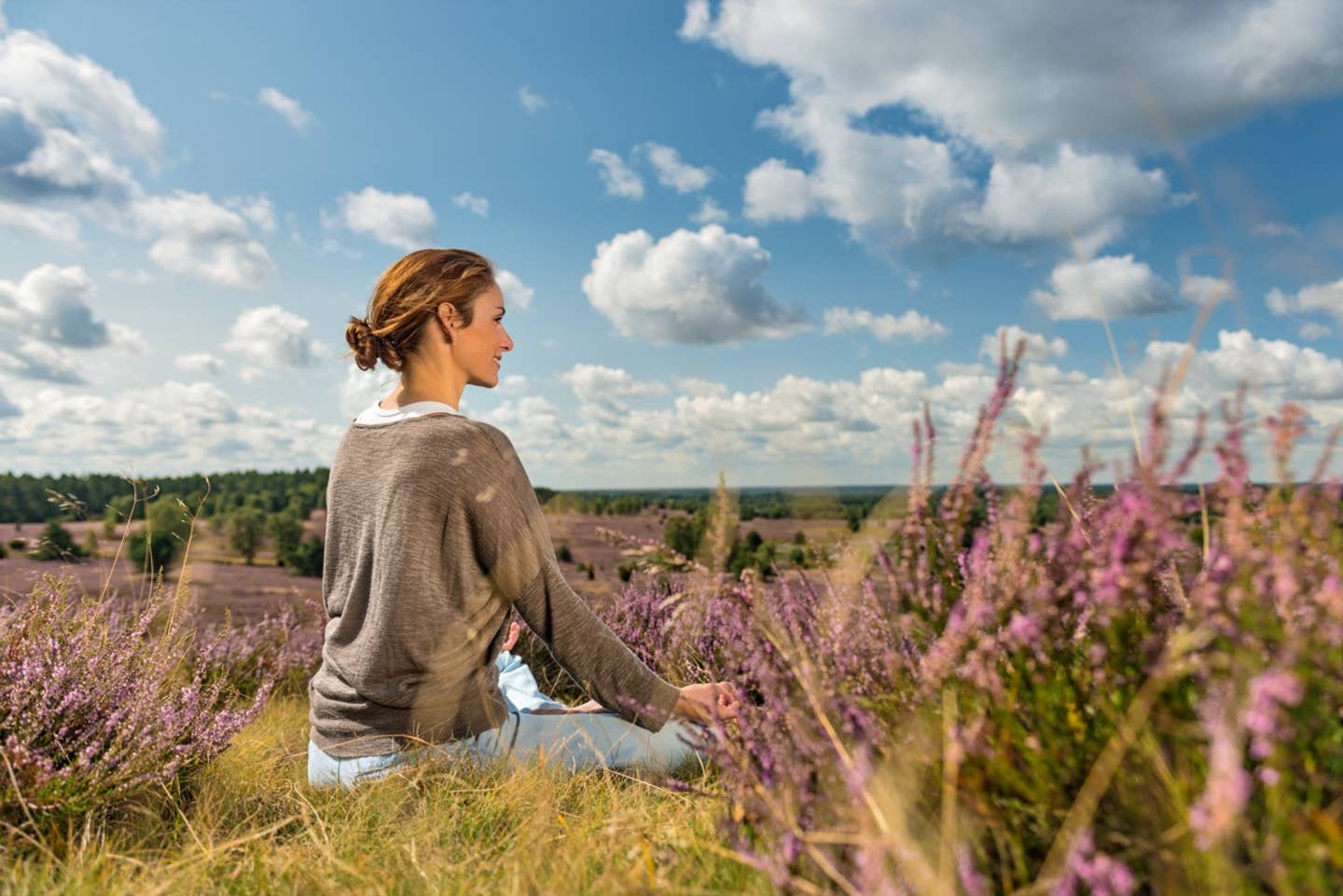 Frau beim Yoga in einem Feld in der Lüneburger Heide