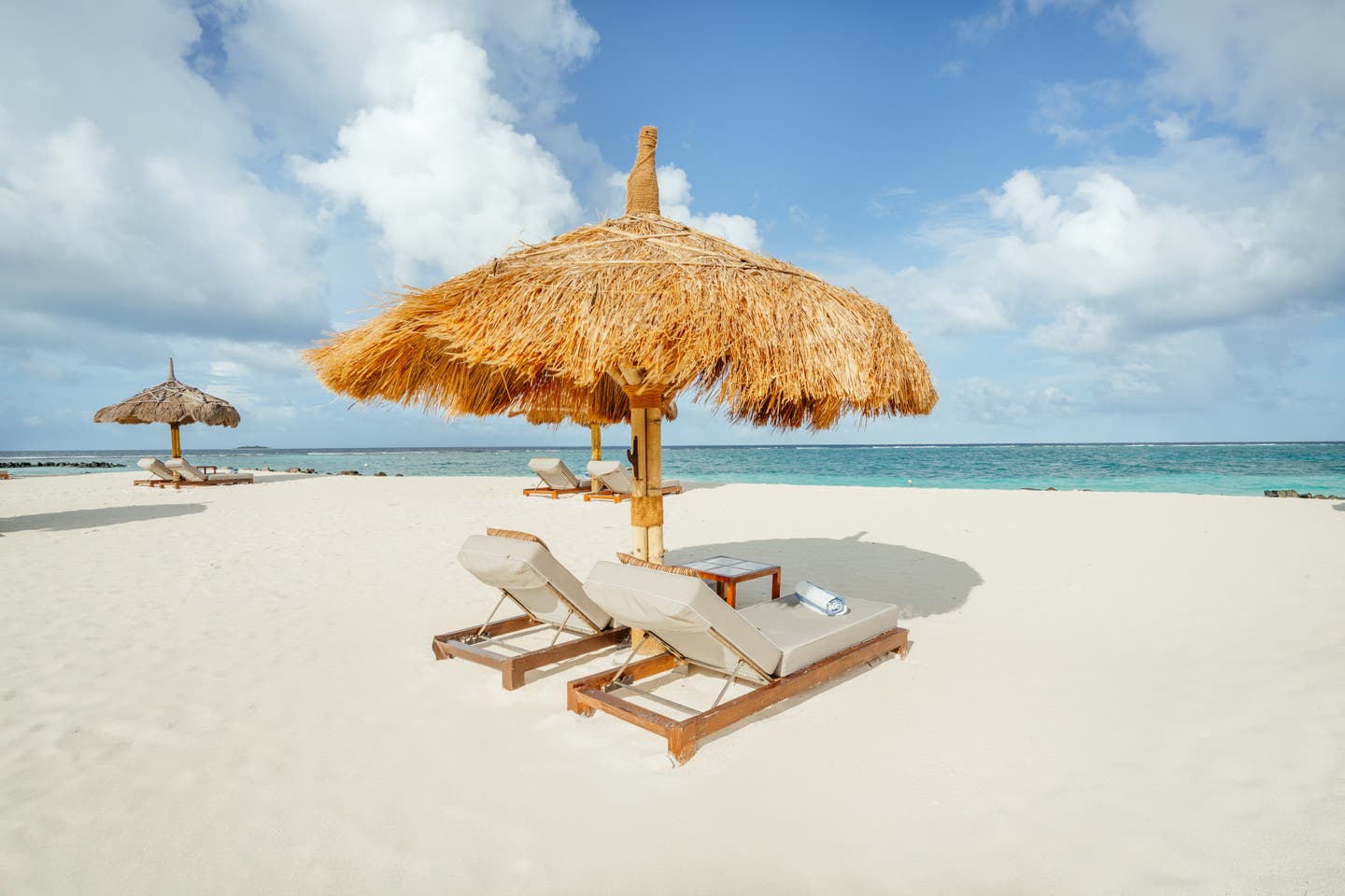 Sonnenliegen und Schirm am Hotelstrand