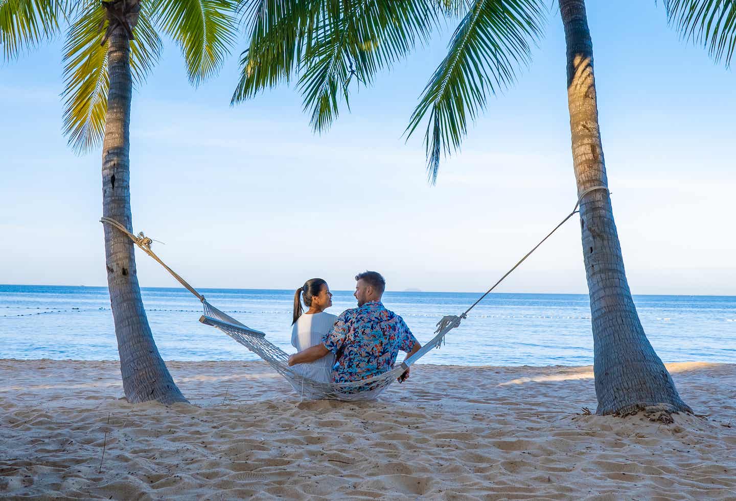 Pattaya zu zweit entdecken - Paar sitzt auf einer Hängematte am Strand