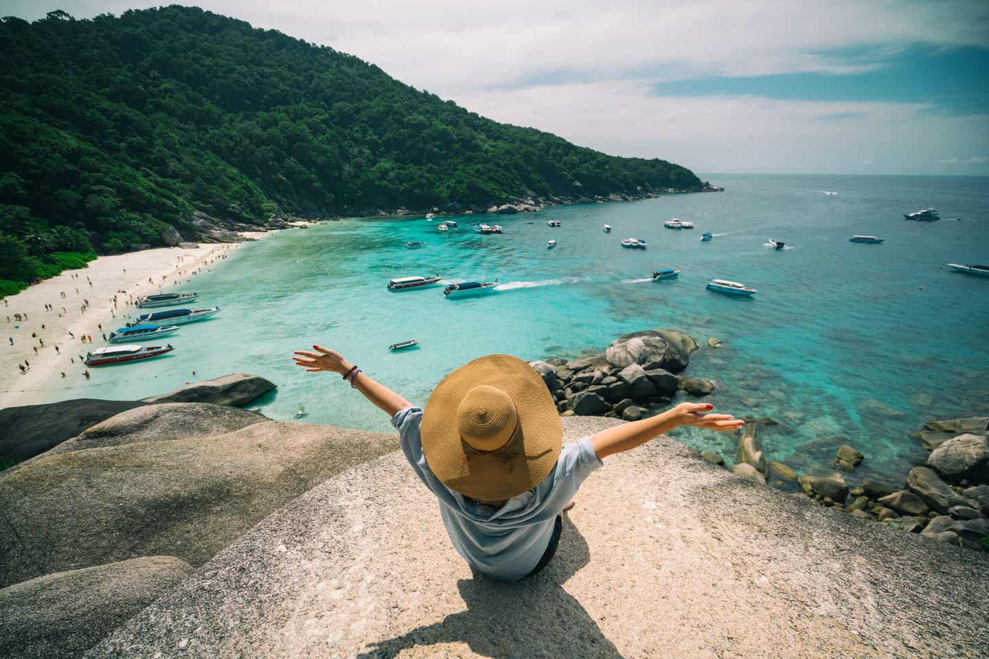 Frau auf einem Felsen der Similan-Inseln mit Blick auf die Bucht