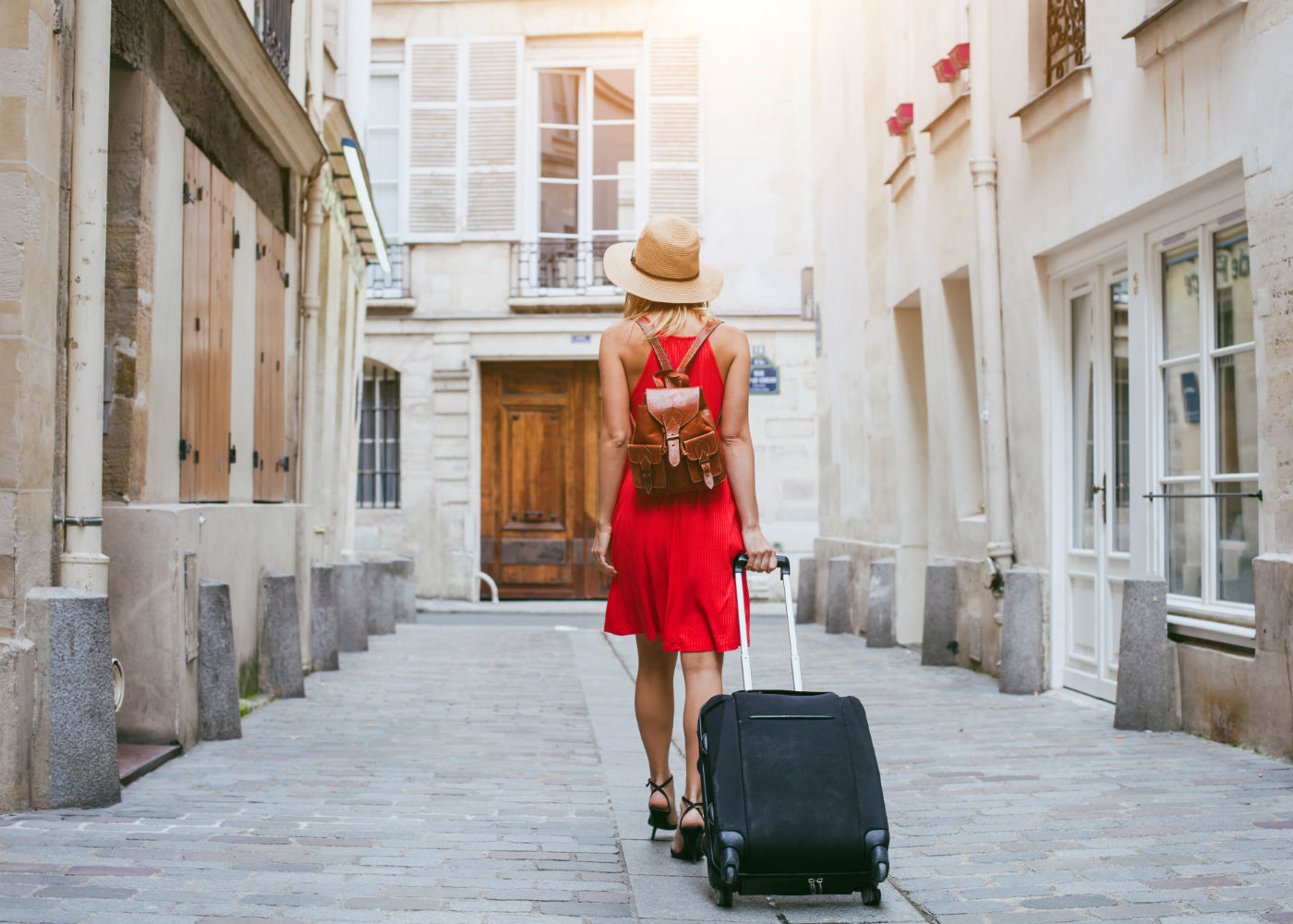 Frau geht mit Koffer durch die Straße