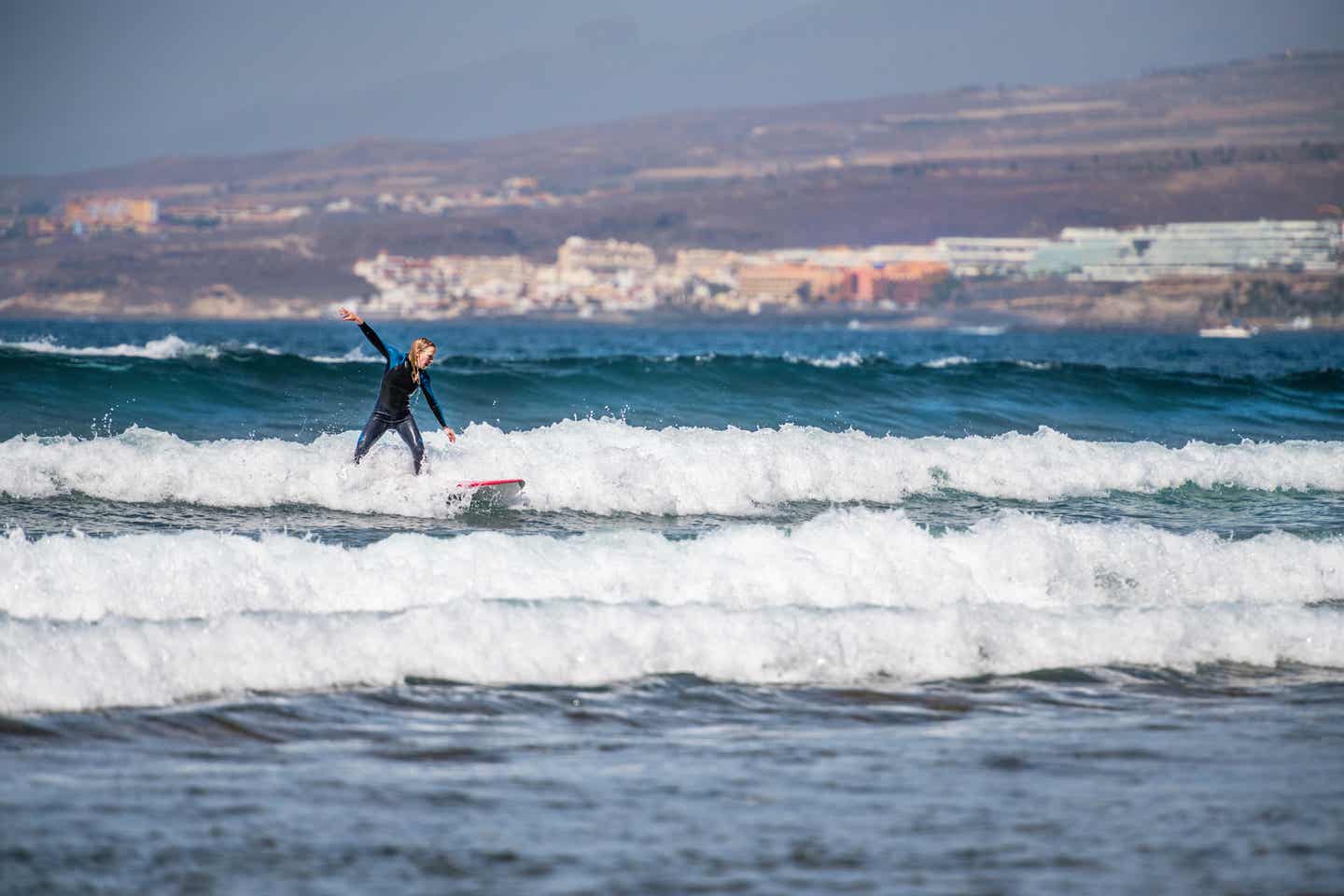 Frau surft im Meer auf Teneriffa