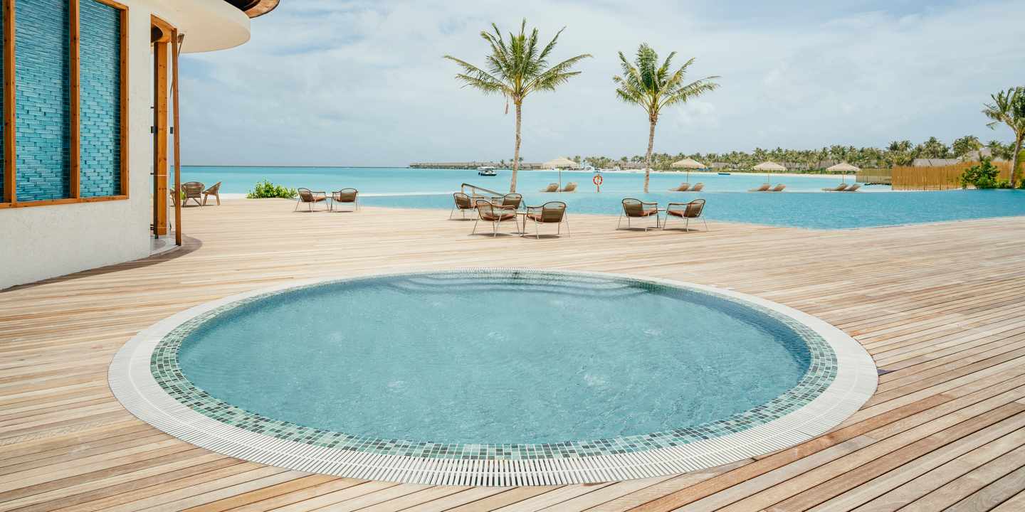 Ein kreisrunder Pool im ananea Madivaru Maldives mit Blick auf das Meer