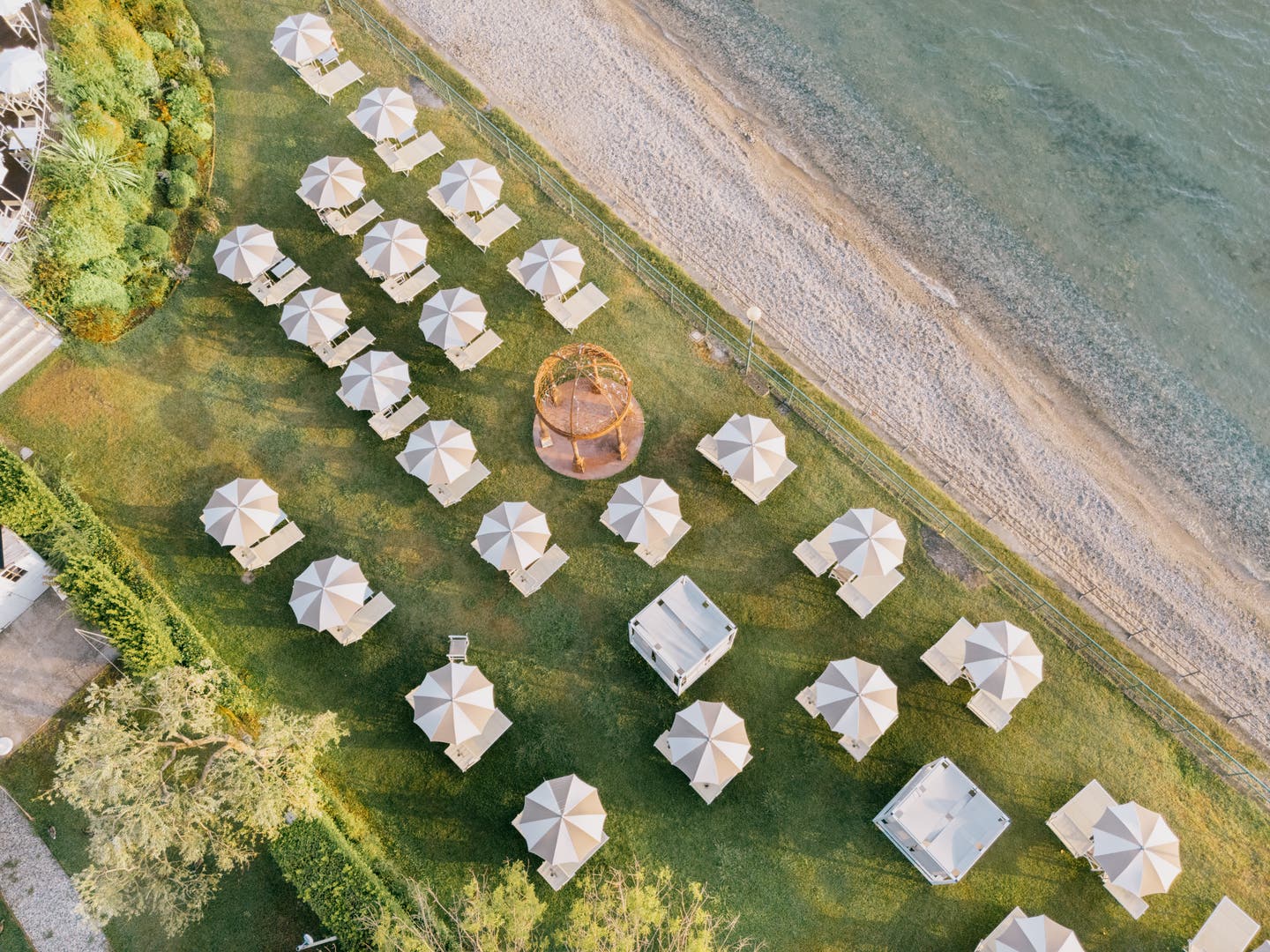 Topshot eines Strandabschnitts mit Sonnenliegen am Gardasee