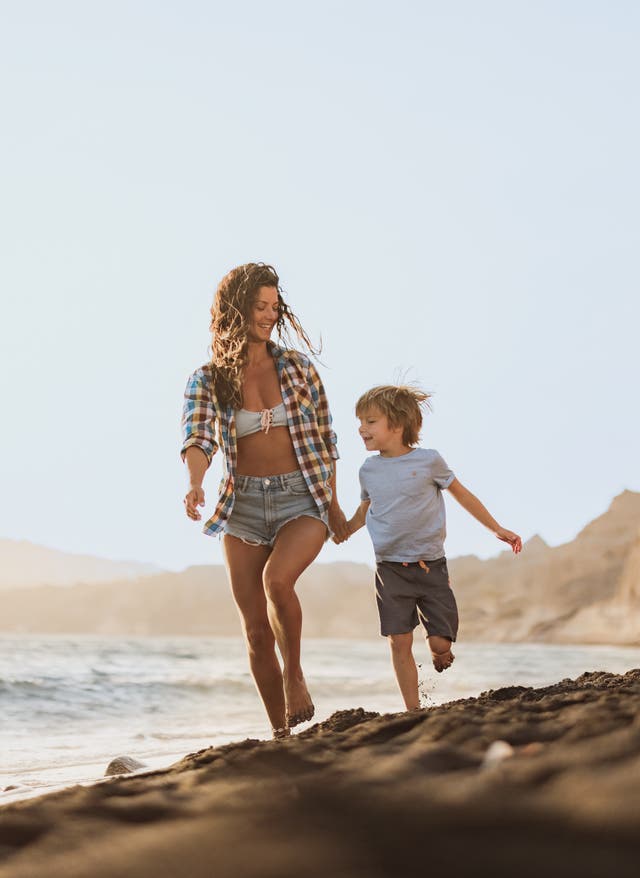 Familienurlaub Griechenland Familienurlaub Griechenland: Mutter und Sohn gehen einen Strand entlang