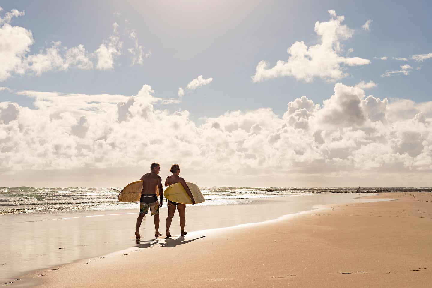 Pärchen mit Surfbretten am Strand an Mallorcas Südküste