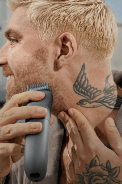 Homem a aparar a barba em frente ao espelho