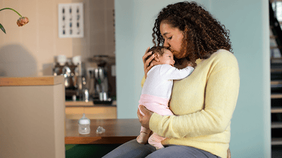 Bebelușul doarme pe pieptul părintelui cu un zâmbet mulțumit