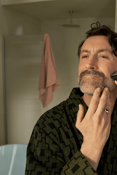 Hombre recortándose la barba con el barbero todo en uno 9000 de Philips