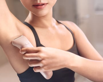 Lady is shaving her underarm