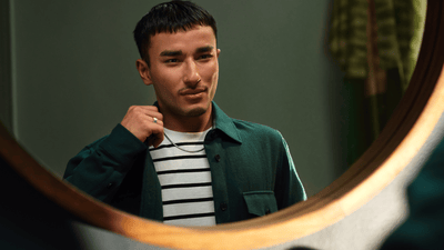 Чоловік з доглянутою бородою посміхається на вулиці