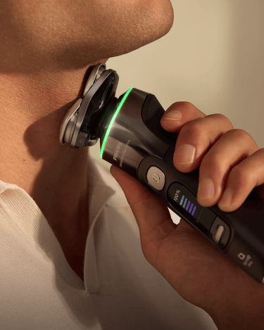 Close-up of a man using a Philips electric shaver on his neck, demonstrating precise trimming and smooth shaving even in hard-to-reach areas.