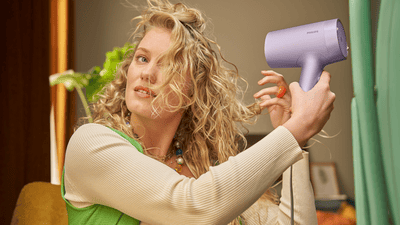 Femeie cu parul blond isi usuca parul