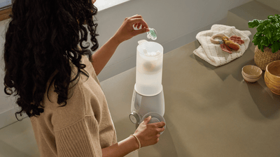 A woman is adding a soother into a steriliser to thoroughly clean and sanitise it.