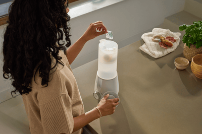 A woman is adding a soother into a steriliser to thoroughly clean and sanitise it.