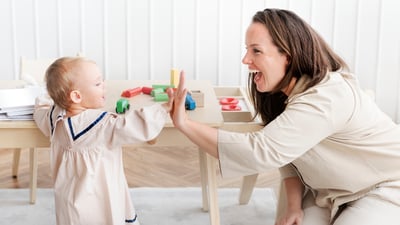Mamă care supraveghează copilul lângă mobilierul din casă