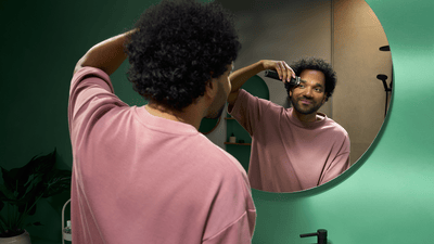 A young man is using the Philips OneBlade Intimate to shave his underarms to potentially avoid smelly odour.