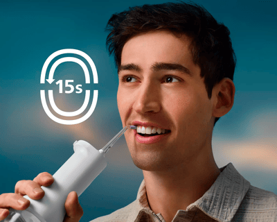Patiënt die een Cordless Power Flosser gebruikt.