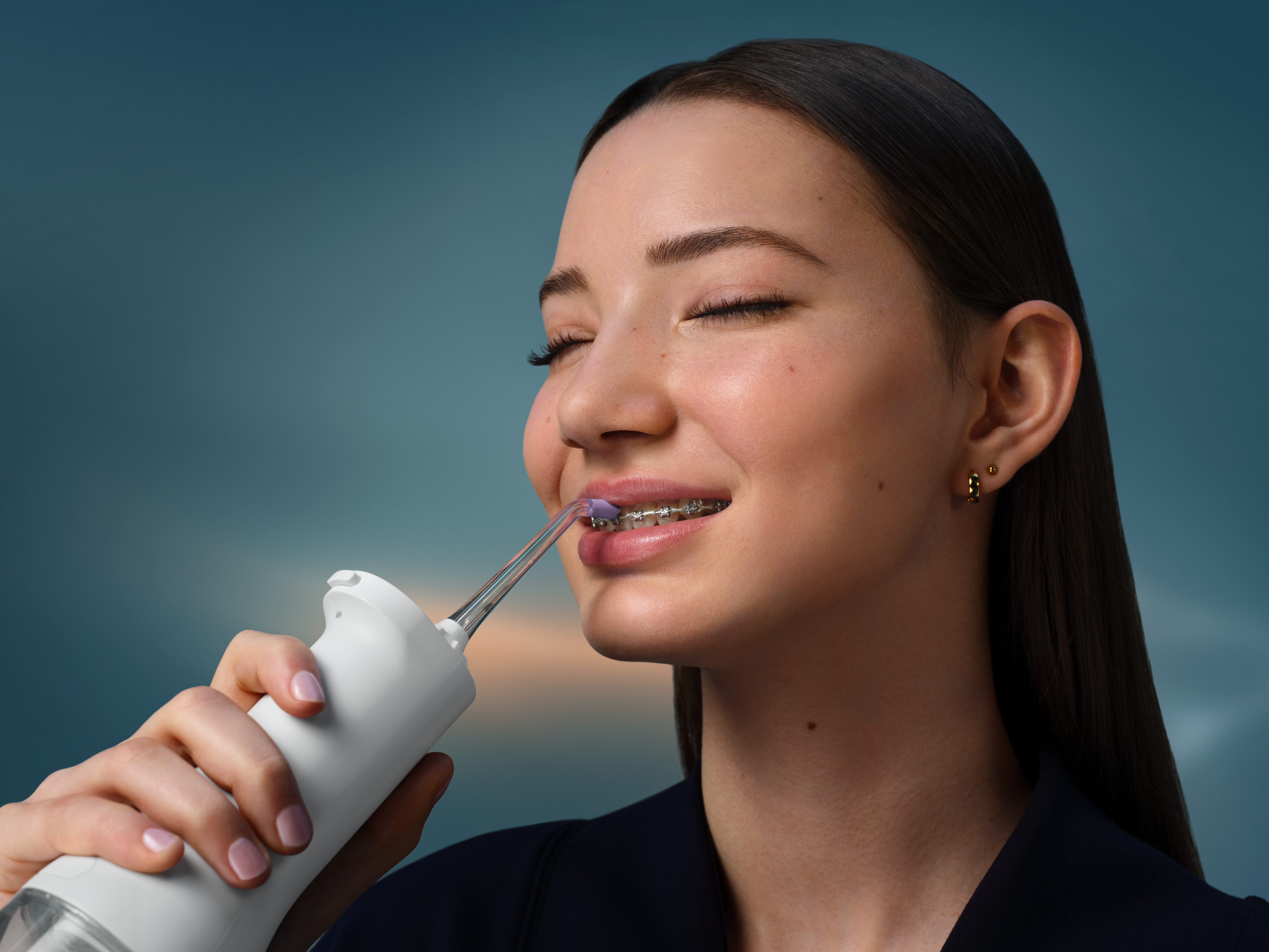 Philips power flosser in use of someone with wearing braces