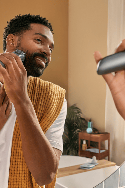 Man shaving his beard in the mirror
