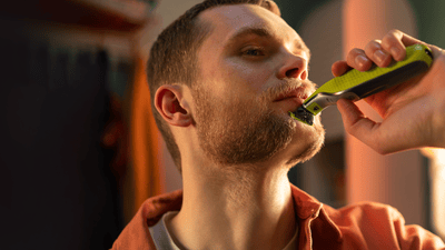 bărbatul îi rade barba pe obraji