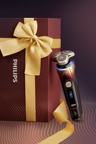 Poklon-set Philips i9000 aparata za brijanje s nastavcima i kutijom, prikazuje svestrane alate za njegu kao premium poklon