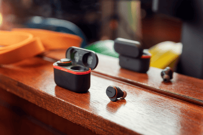 Philips sportoordopjes en oplaadcase geplaatst op een houten oppervlak binnenshuis