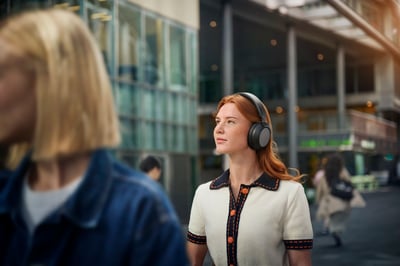 Vrouw die Philips noise-cancelling in-ear hoofdtelefoons draagt in de stad.